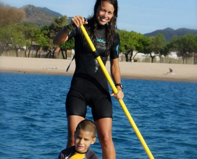 monitora y nino en el mar junto a una pala de sup.jpg